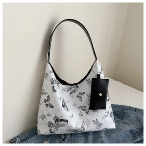 Gros plan du sac cabas à motif papillon avec bandoulière et petite pochette amovible