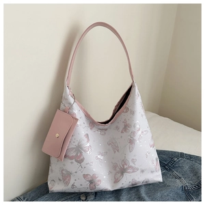 Détail du sac cabas imprimé papillon avec petite pochette zippée assortie sur fond denim