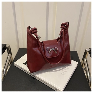 Détail du sac hobo bordeaux avec boucle nœud argentée et bandoulière torsadée