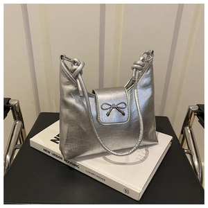 Détail du nœud métallique argenté sur le sac froissé avec bandoulière à nœud unique