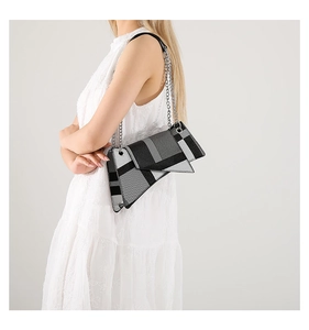 Detail of geometric asymmetric crossbody bag with plaid pattern and silver chain