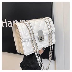 Close-up of white quilted chain bag featuring silver metal twist lock and leather strap