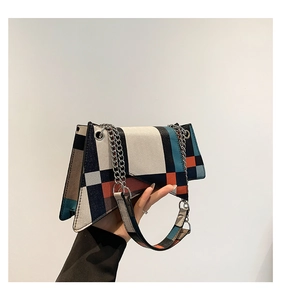 Detail of color-block patchwork shoulder bag with geometric design and dual straps