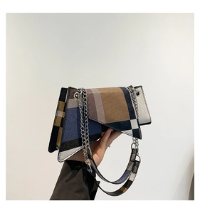 Detail of color-block geometric handbag featuring silver chain and wide shoulder strap