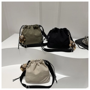 Tre borse a secchiello con coulisse in oliva, nero e beige con simpatici portachiavi a scimmia