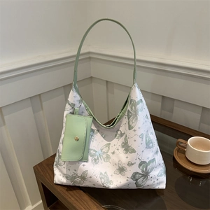 Elegant butterfly print tote bag with small matching pouch on a wooden tabletop