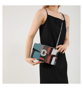 Détail du sac à bandoulière rayé multicolore avec boucle en cristal et chaîne argentée