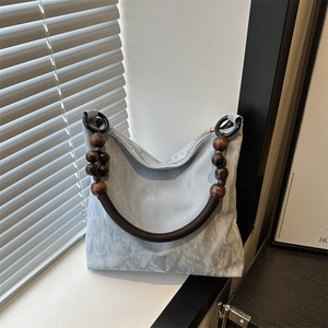 Light blue pleated tote bag with unique wooden bead handles and braided rope detail