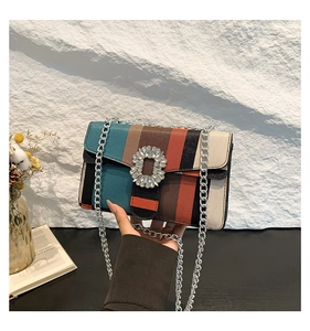 Détail du sac à main rayé multicolore avec boucle en cristal et bandoulière chaîne argent