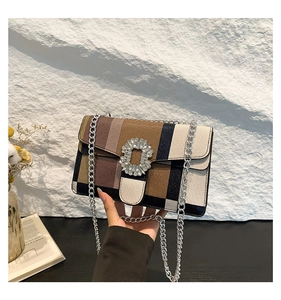 Détail du motif à carreaux colorés et de la boucle en strass sur un sac à bandoulière