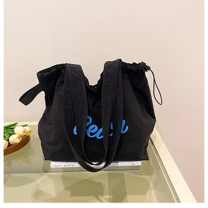 Détail du sac cabas en toile noire avec imprimé Pear bleu clair et cordon de serrage