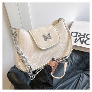 Close-up of marble texture underarm bag featuring a metallic butterfly buckle and silver chain