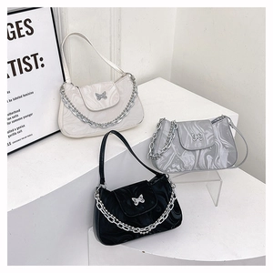 Detailed macro view of marble textured crescent bags with butterfly metal buckles