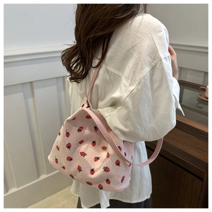 Detailed close-up of pink corduroy tote bag featuring red strawberry embroidery pattern