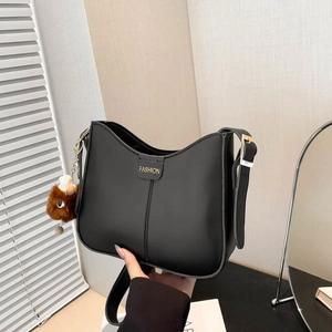 Chic black hobo shoulder bag with fashion label and brown plush charm for women