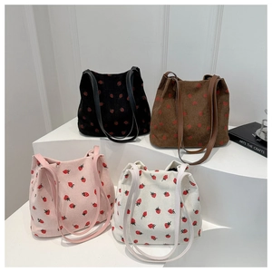 Detailed corduroy tote bags with strawberry prints in four colors on a white display