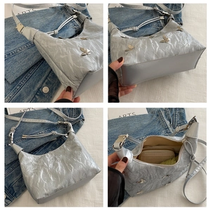 Gros plan du sac fourre-tout argenté plissé avec boucle papillon et intérieur spacieux