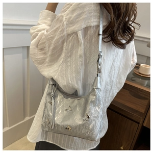Détails du sac argenté à papillons montrant la texture y2k et la bandoulière