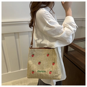 Détail du sac en paille avec fraises brodées et broderie du texte fashion dessus