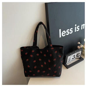 Détail du sac cabas en velours côtelé noir à motif fraise sur fond de style de vie