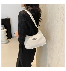 Detailed side view of the white nylon crescent bag with adjustable wide shoulder strap