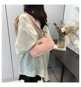 Detail of pink nylon hobo bag showing the curved design and brand logo on shoulder