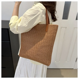 Brown woven tote bag detail featuring wave texture and brown leather shoulder straps