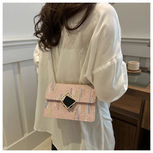 Detail of light pink chain bag featuring colorful wave embroidery and geometric metal lock