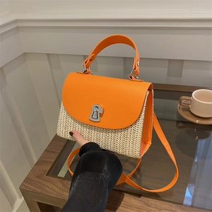 Fashionable straw crossbody handbag with orange leather flap and metallic buckle