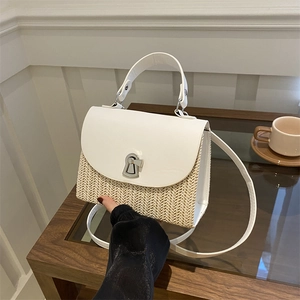 Chic woven straw handbag with white leather flap and silver metal lock closure