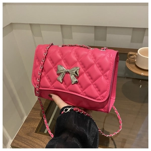 Détail du sac bandoulière matelassé rose avec nœud métallique argenté et chaîne
