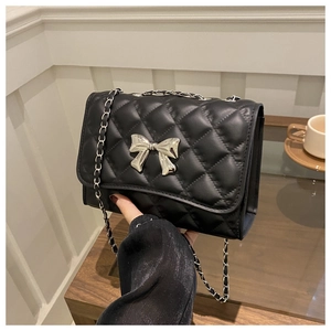 Détail du sac matelassé noir avec une boucle décorative en métal argenté