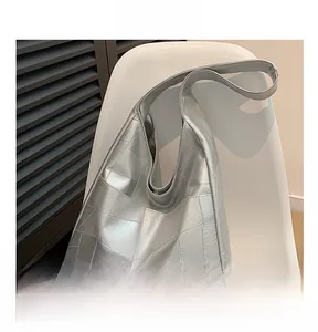 Detail of silver metallic tote bag featuring geometric stitching and soft leather texture