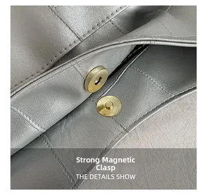 Detail view of strong magnetic clasp on silver-grey pebbled leather handbag with fine stitching
