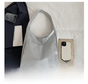 Silver geometric patchwork tote bag with wide strap compared to iPad and phone