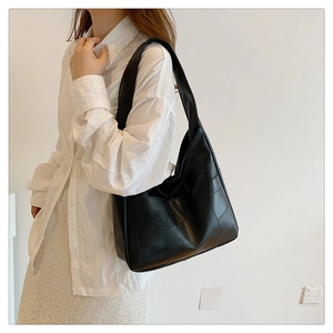 Macro shot of black matte leather tote bag with square panel stitching for work