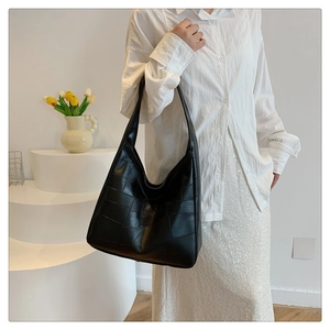 Detailed view of the black geometric leather tote bag with wide shoulder strap