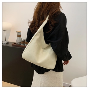 Detail of off-white quilted shoulder bag with geometric stitching for office wear