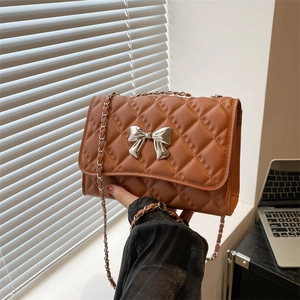 Sac à bandoulière matelassé marron avec nœud argenté et chaîne élégante