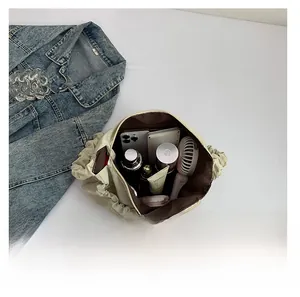 Interior view showing the large capacity of the beige drawstring cloud crossbody bag