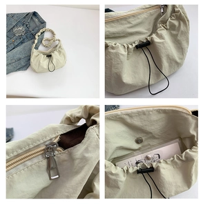 Detail view of nylon crescent bag with drawstring, zipper, and magnetic closure