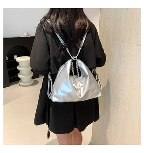 Detail of silver metallic PU shoulder bag with chain strap and pearl charm on a model