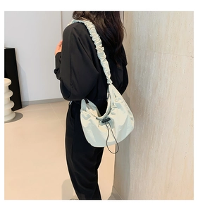 Detail of cream nylon tote bag featuring adjustable drawstring and ruffled cloud strap