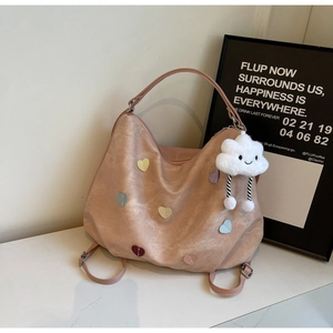 Detail of light pink tote bag with colorful heart patches and plush cloud charm
