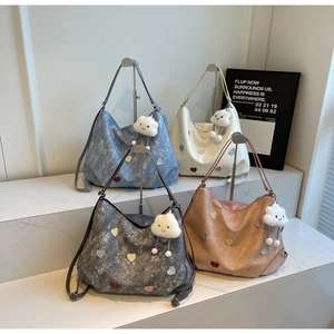 Multiple colors of heart-patterned tote bags with cloud charms on display stands
