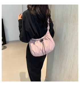 Detail of pink pleated crossbody tote bag with adjustable drawstring and nylon fabric