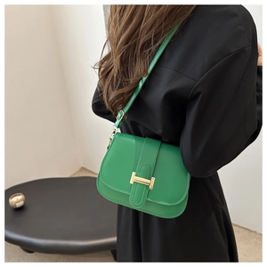 Close-up of vibrant green crossbody bag featuring a classic gold-tone H-shaped buckle