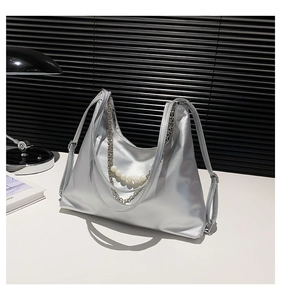 Close-up of silver hobo bag with metallic finish, pearl charms and metal chain details