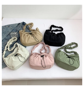 Detailed view of gathered tote bags in khaki, black, cream, pink, and green colors