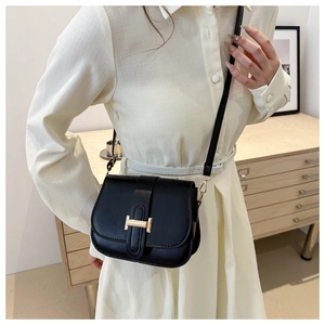 Classic black leather crossbody bag featuring an elegant gold H buckle shown on a model